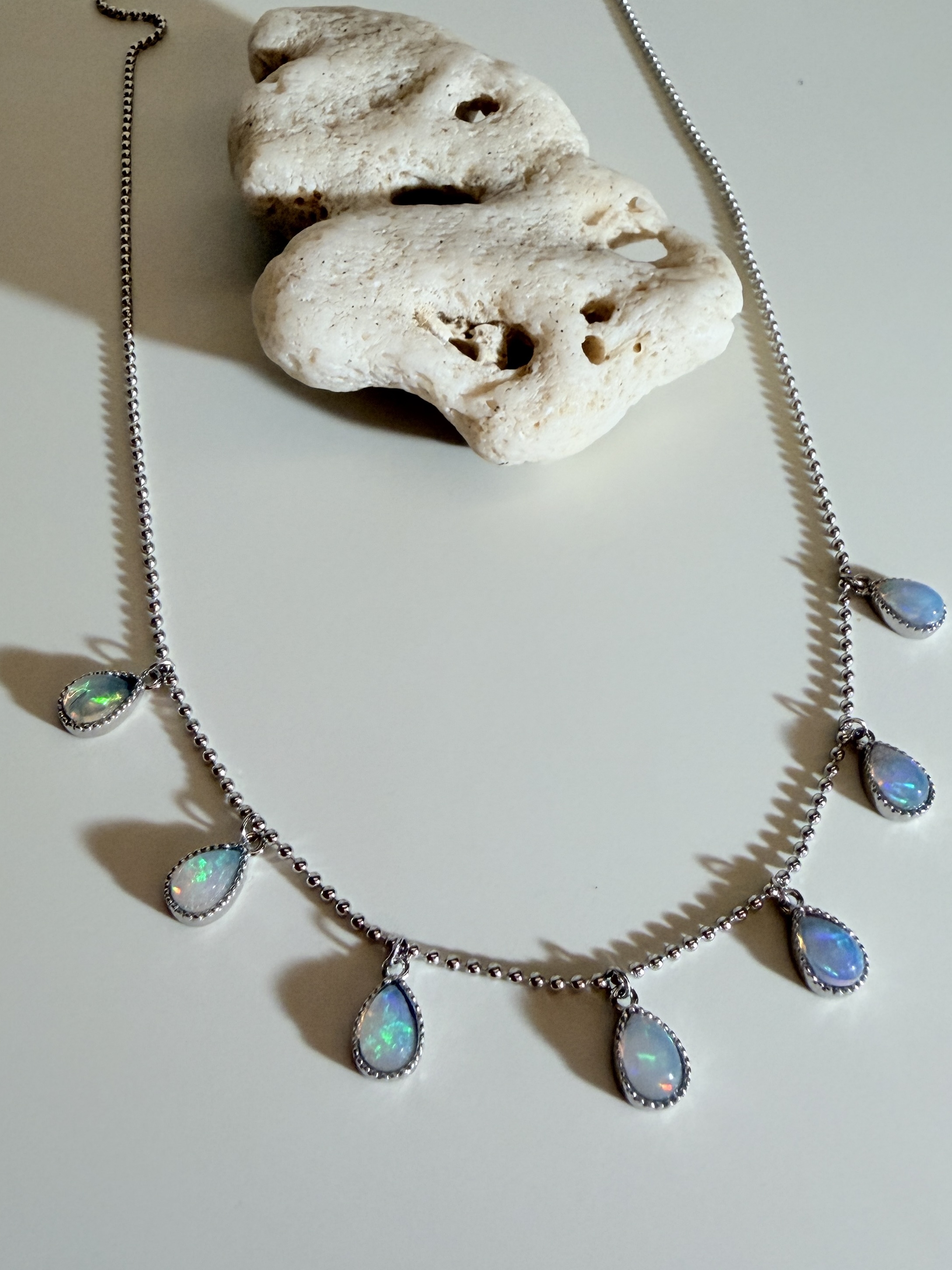 Opal necklace shaped from the same luminous material language